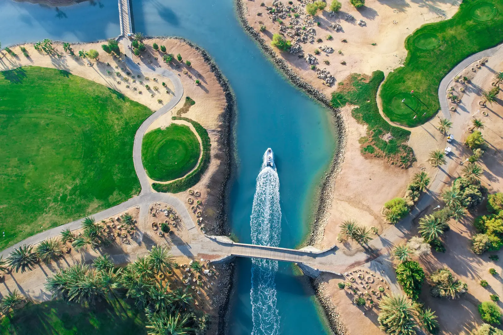 Boat crossing a narrow lagoon between the fairways of El Gouna's golf course